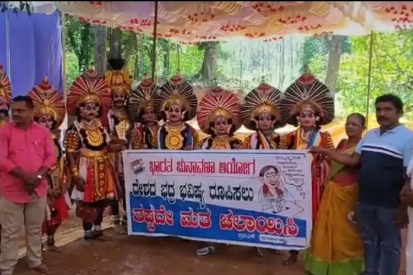 Artists dressed as Yakshagana holding banners about voting